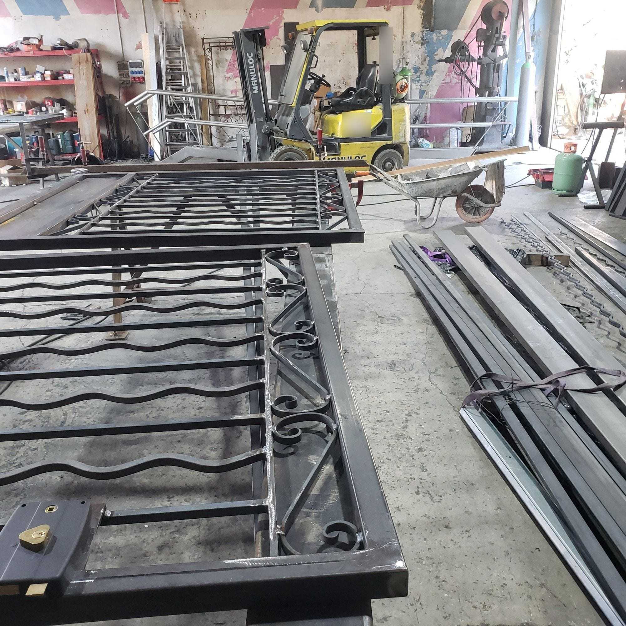 Two scrolled wrought-iron style gates being fabricated in the workshop