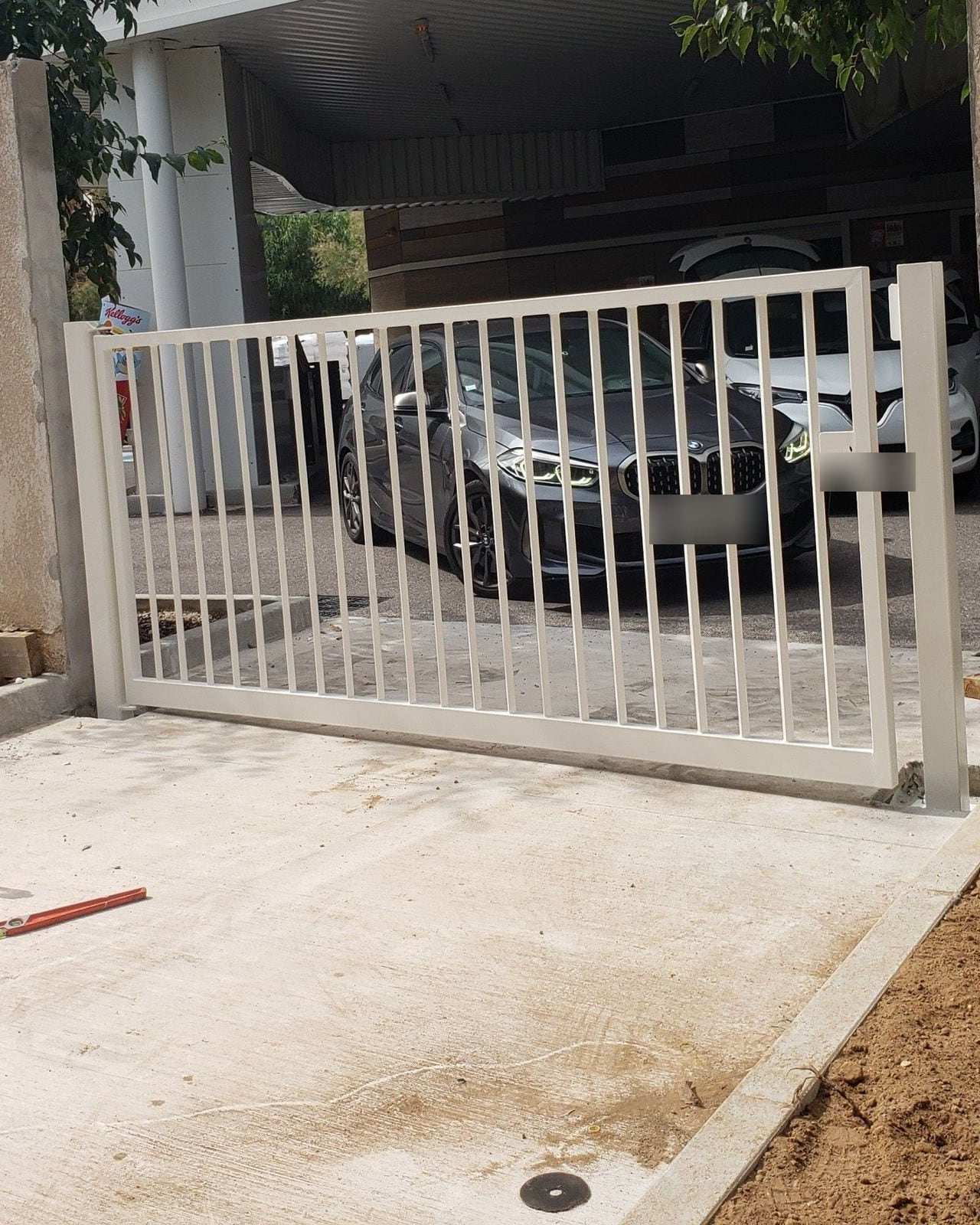White sliding gate installed, vertical bars